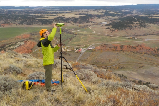 After climbing to the top of Devils Tower a NPS employee places a real time kinematic survey